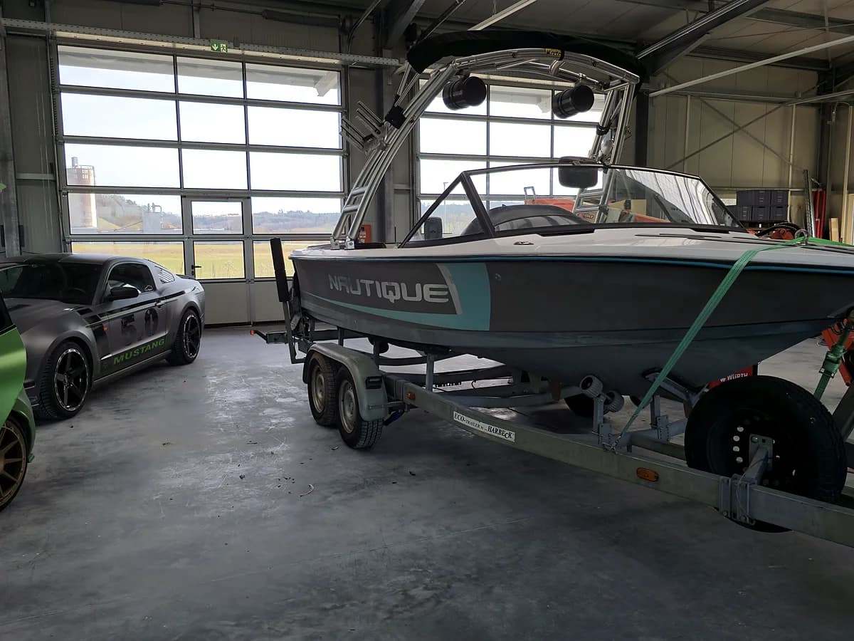 Auch Boote bekommen bei ARS:MOOSIX Sound: Motorboot in der Werkstatt neben einem Showcar