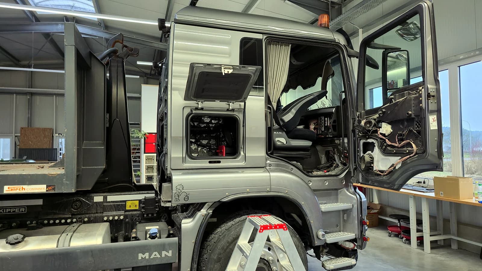MAN LKW mit geöffnetem Fahrerhaus in der ARS:MOOSIX Werkstatt